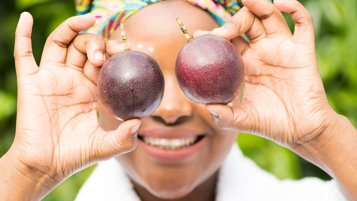 woman holding passion fruit