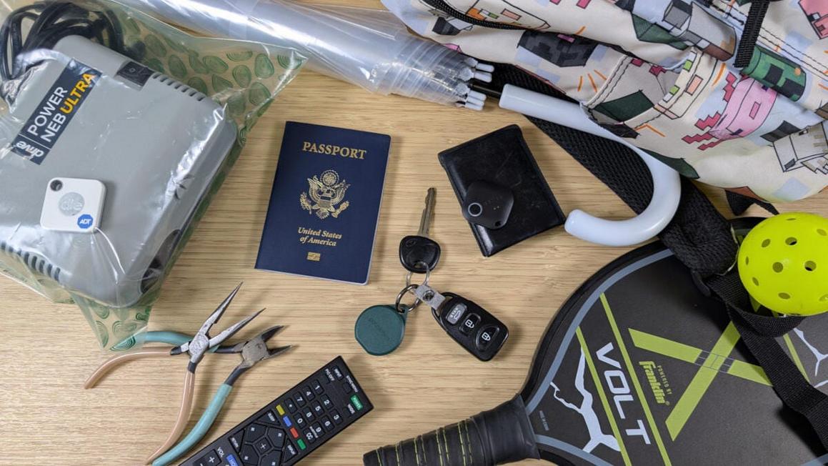 bluetooth trackers and various trackable items on bamboo desk