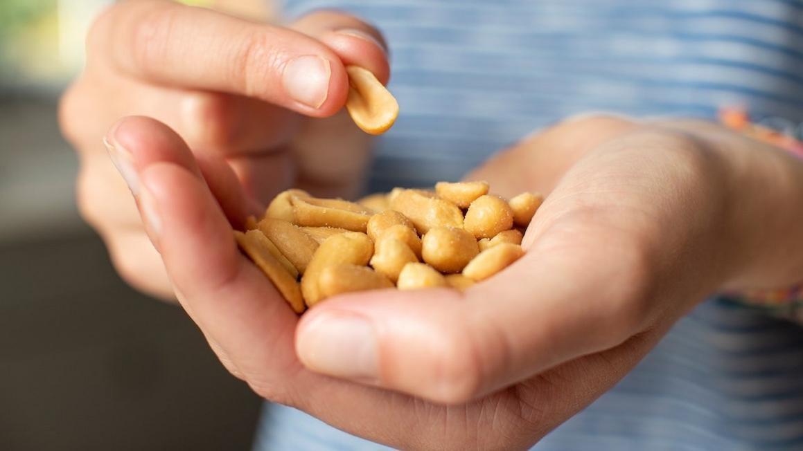 person with handful of peanuts