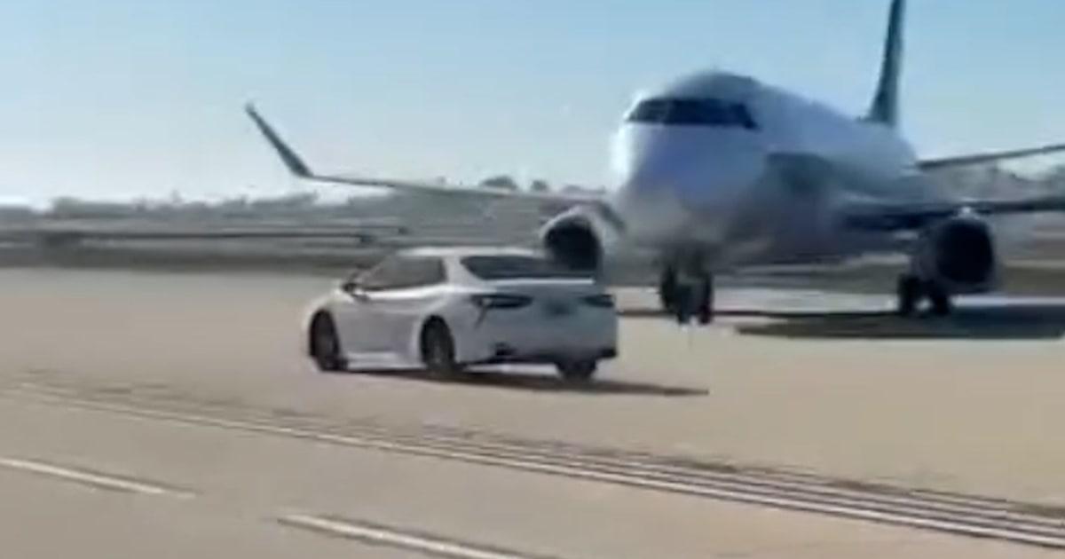 Xe hơi chạy trên đường băng tại phi trường John Wayne 1 f vert brk airport car speeds 251210.00 00 34 08.Still002 arw8yp