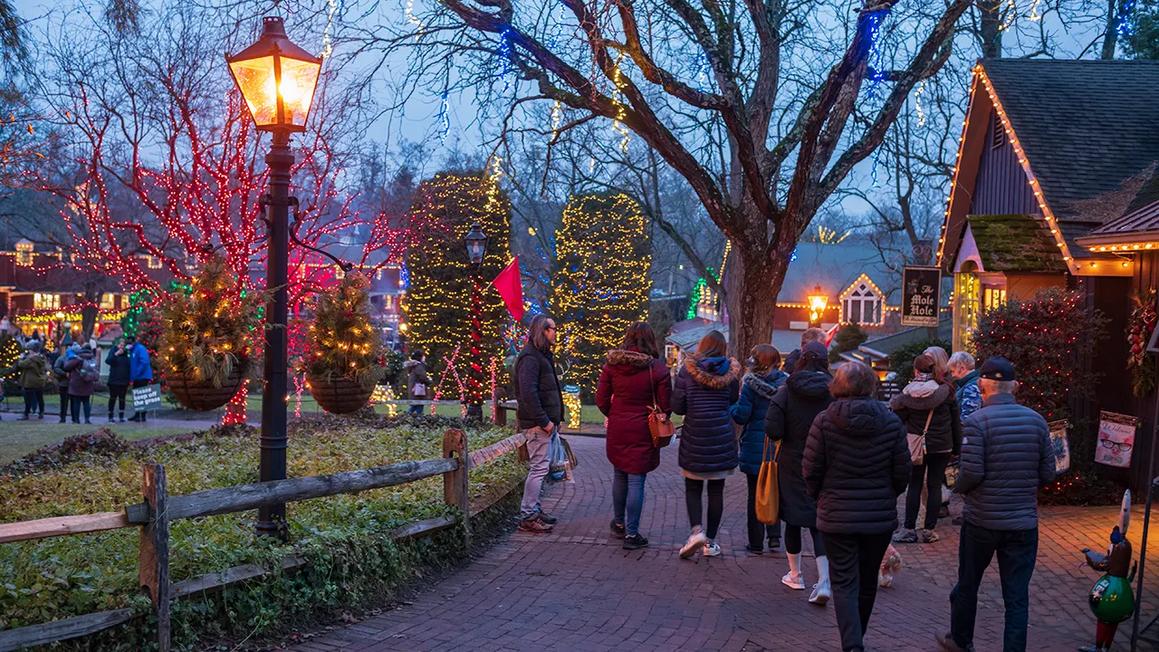 visitors walking through christmas village
