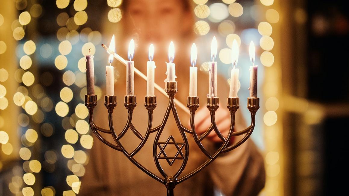 woman lighting menorah