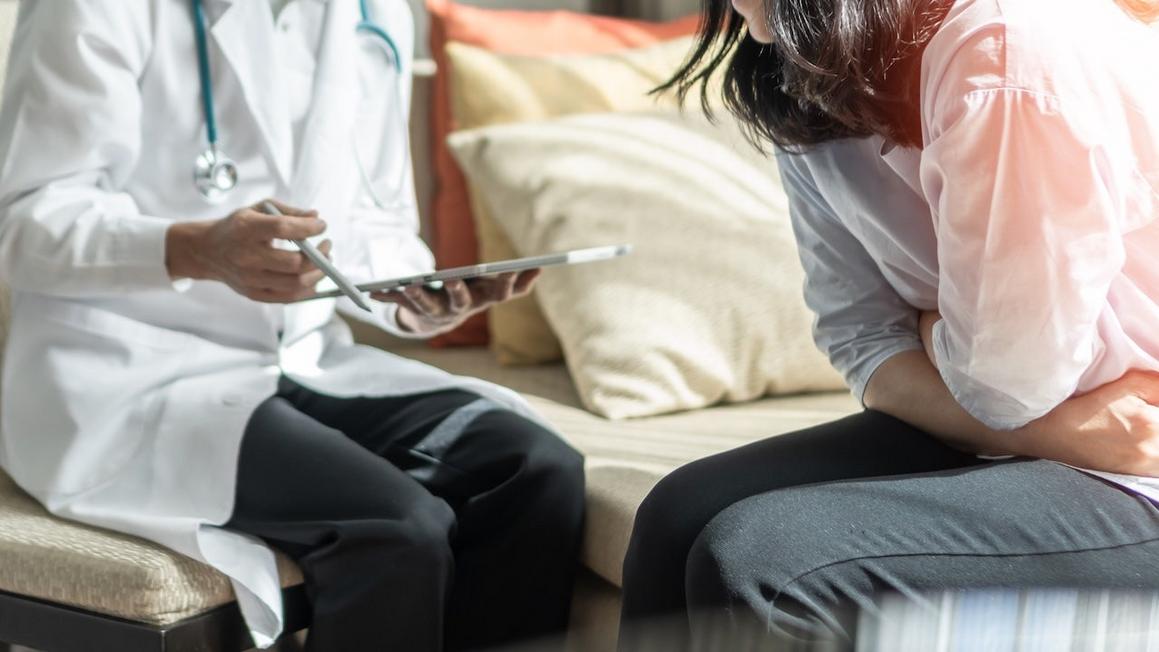 woman stomach pain at doctor pancreatic cancer