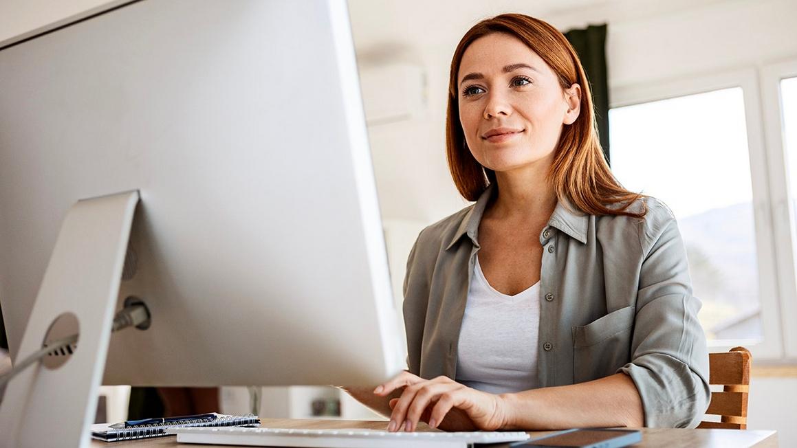 woman types on desktop computer