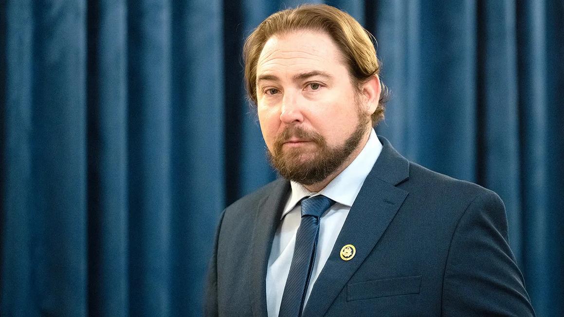 eli crane stands in front of curtain