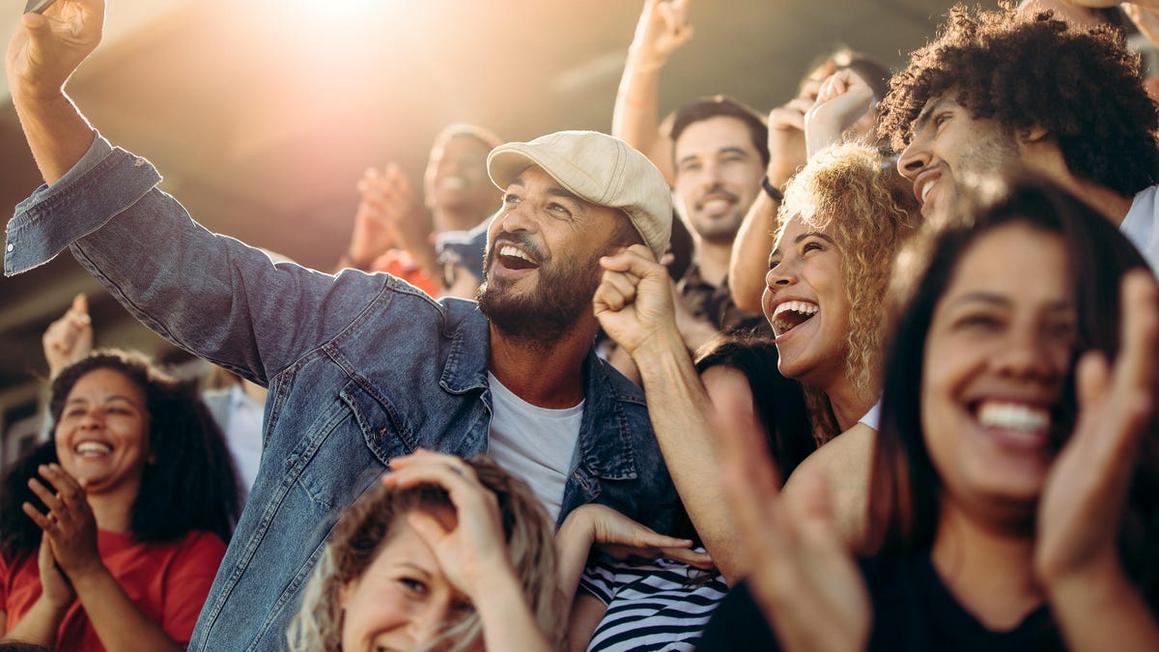 group of supporters taking selfie watching a football match jacob lund adobe stock