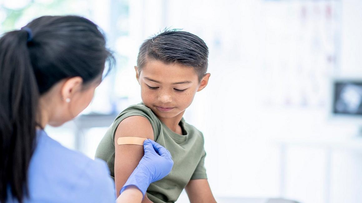 CDC Cắt Giảm Lịch Tiêm Chủng Cho Trẻ Em, Gây Tranh Cãi 1 kid receiving shot