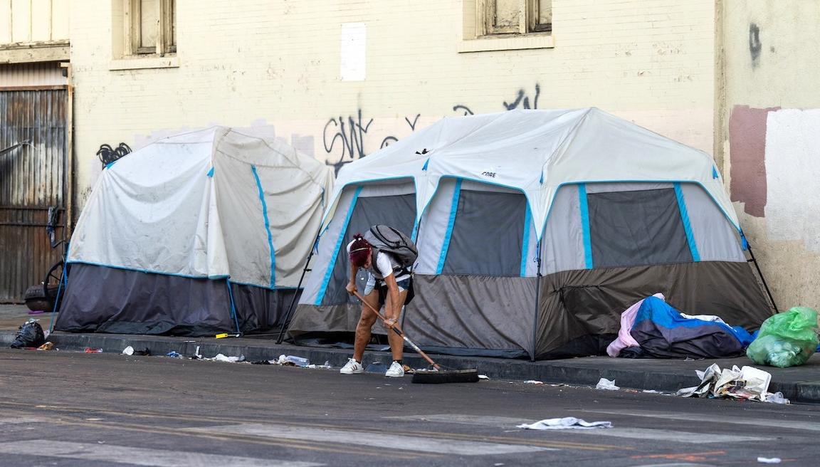 man cleaning up homeless camp