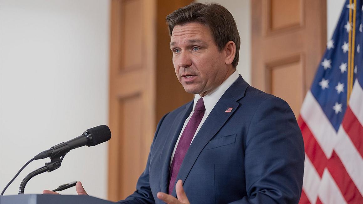 ron desantis stands at podium