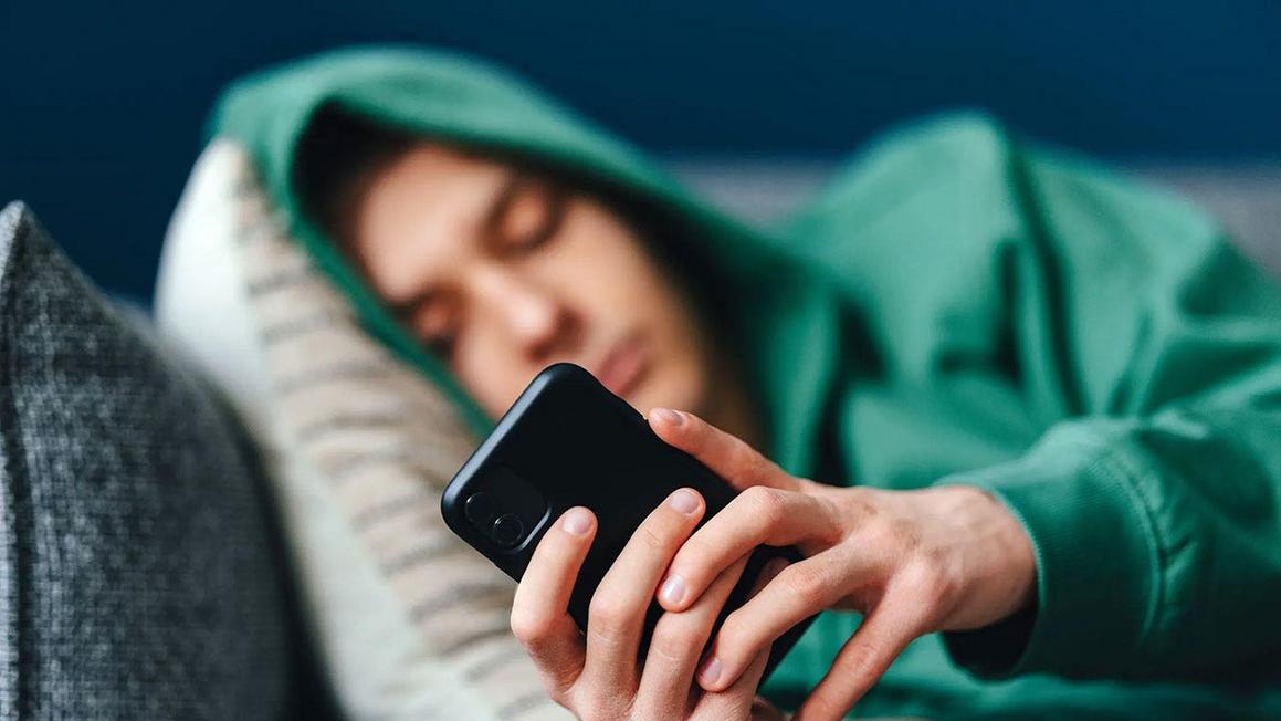 sad teen boy on couch smartphone