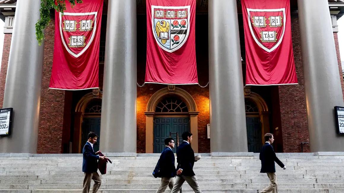 students walking harvard banners optimized