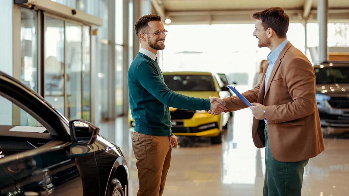 two men shaking hands car dealership