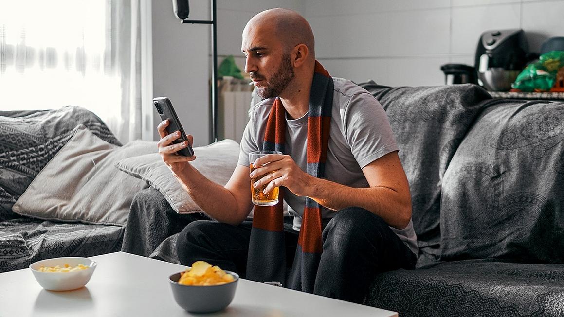 sports fan checks phone during game